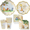 Party supplies with Winnie the Pooh design including plates, cups, and napkins.