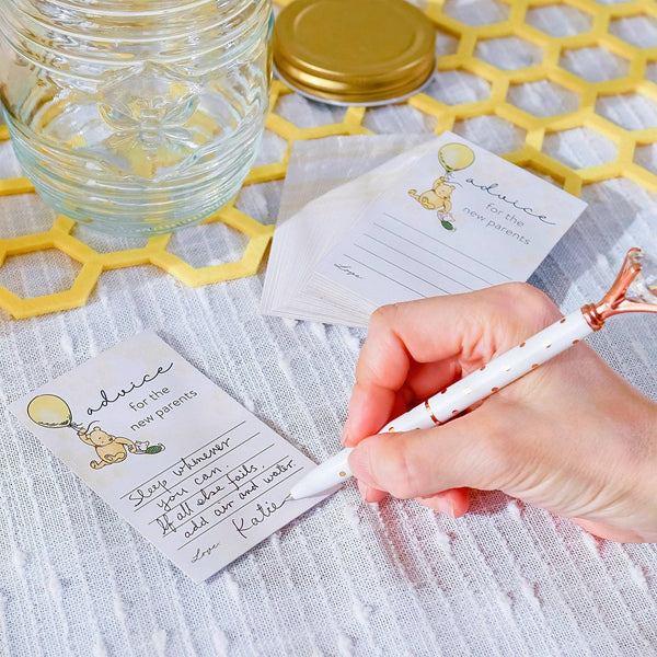 Hand writing on a card with a glass jar and decorative elements in the background