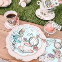 Tea party setup with Alice in Wonderland theme, including teacups, plates, and a clock.