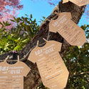 Kraft paper baby onesie-shaped cards with predictions and advice on a tree branch.