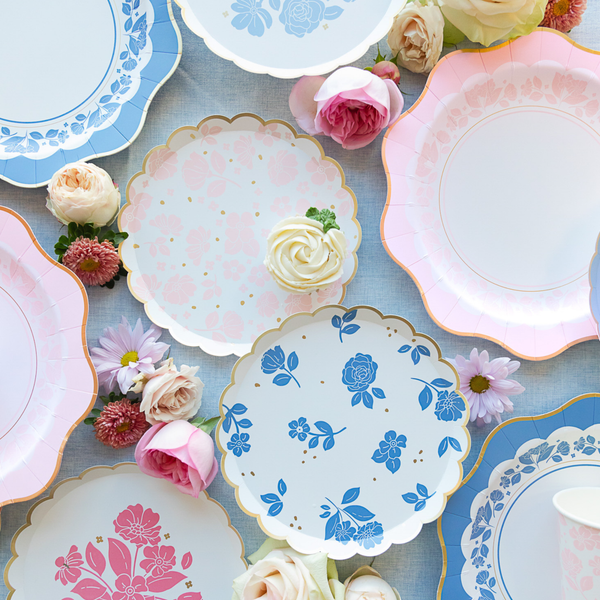 Decorative paper plates with floral designs on a blue surface with flowers.