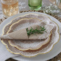 Decorative table setting with lace-rimmed plates and burlap napkins.