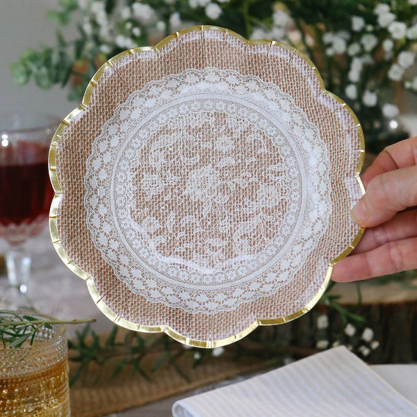 Decorative plate with lace design held by a hand, with a blurred background of a table setting.