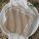 Brown paper napkins with lace trim on a white plate.