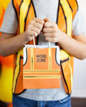 Person wearing a high-visibility vest holding a 'Work Zone' bag.