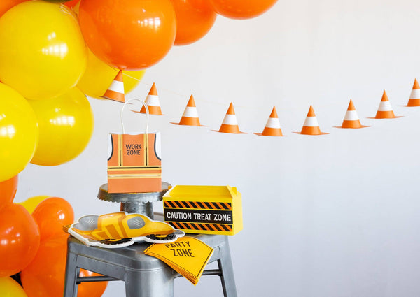 Construction-themed party decorations with balloons, cones, and signs on a white background