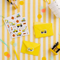 Construction-themed stickers and envelopes on a yellow and white striped background