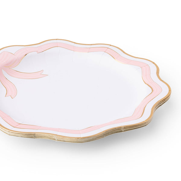 Set of white plates with pink rims and gold edges on a white background