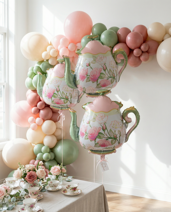 Decorative setup with floral teapots and balloons in a room.