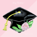 Graduation cap balloon with floral design on a pink background