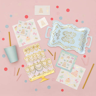 Decorative items including a tray, cups, and cake-themed stickers on a pink background with confetti.