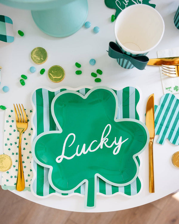 St. Patrick's Day-themed table setting with a green shamrock placemat, gold coins, and clover decorations.