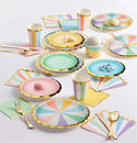 Colorful paper plates, cups, and utensils on a white surface