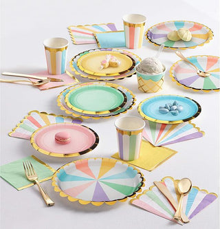 Colorful paper plates, cups, and utensils on a white surface
