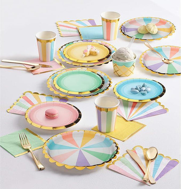 Colorful paper plates, cups, and utensils on a white surface