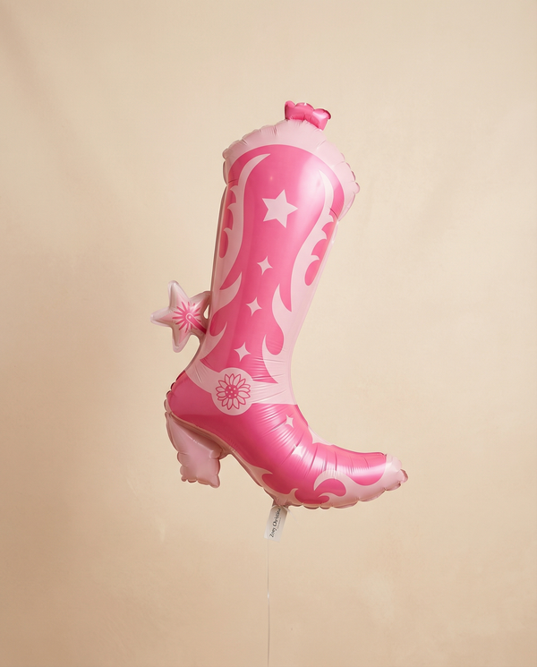 Pink balloon shaped like a boot with floral designs on a beige background