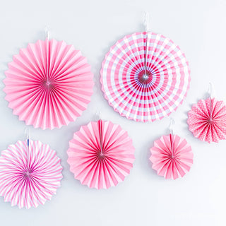 Set of pink paper fans on a light gray background