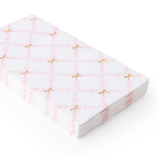 Stack of pink and gold patterned paper napkins on a white background
