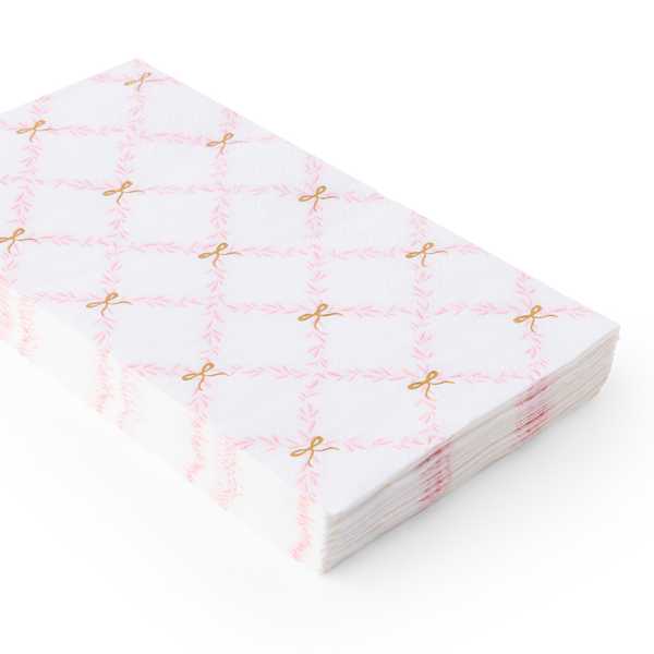 Stack of pink and gold patterned paper napkins on a white background