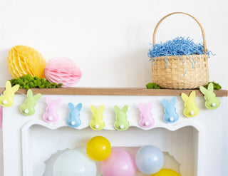 Decorative shelf with Easter-themed items including a basket, balloons, and a bunny banner.