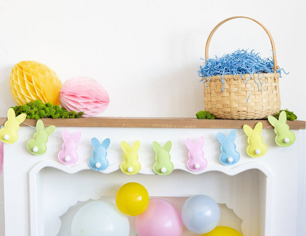 Decorative shelf with Easter-themed items including a basket, balloons, and a bunny banner.