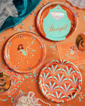 Decorative plates with artistic showgirl designs on a colorful background