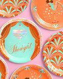 Decorative plates with art deco designs and 'Showgirl' text on a pink background