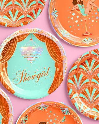 Decorative plates with art deco designs and 'Showgirl' text on a pink background