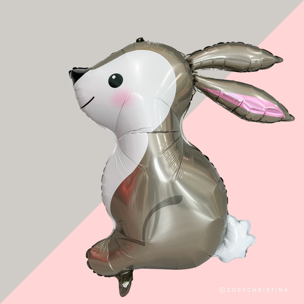 Metallic silver bunny-shaped balloon on a pink and gray background