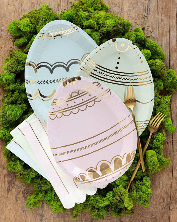 Decorative Easter egg plates with gold patterns on a green moss background