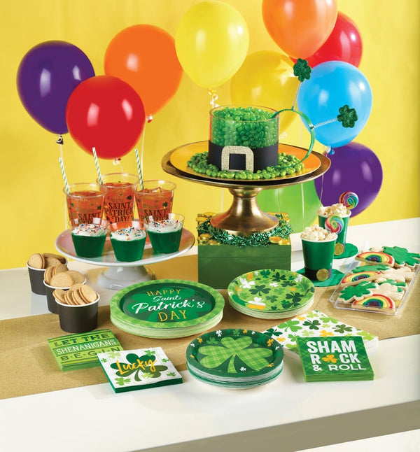 St. Patrick's Day party table with green decorations, balloons, and food.