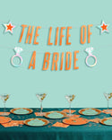 Decorated table with 'The Life of a Bride' theme on a teal background