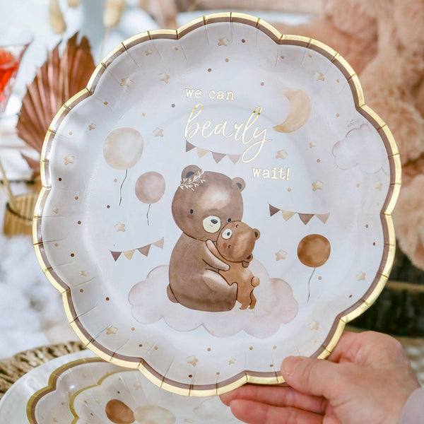 Decorative plate with teddy bear design and text 'we can barely wait!' held by a hand.