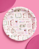 Round plate with book-themed design on a pink background