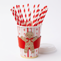 Gingerbread cup with its lid beside it and 20 red-and-white striped straws loosely arranged inside