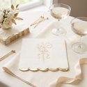 Gold foil floral cocktail napkins styled on a cream-and-gold bridal drinks table