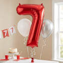 Red number 7 foil balloon with white and silver balloons styled for a seventh birthday celebration
