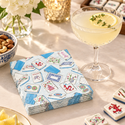 Mahjong cocktail napkins beside a citrus drink