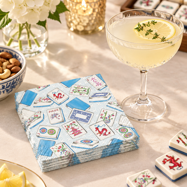 Mahjong cocktail napkins beside a citrus drink