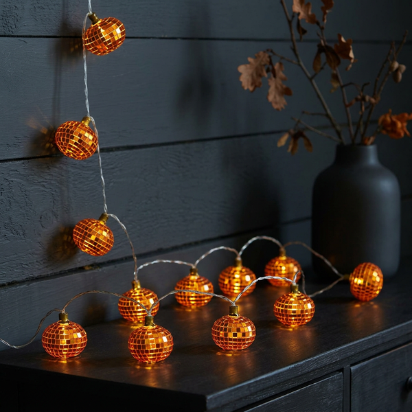 Pumpkin disco string lights glowing in a dark space