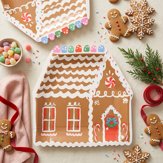 Styled gingerbread house plates on a festive cookie-decorating table